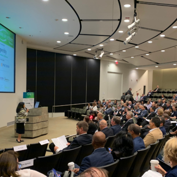 Texas Life Science Forum presenter in front of crowd with screen in background